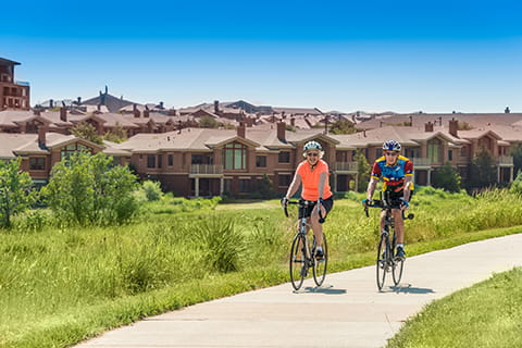 A couple rides their bikes through Vi at Highlands Ranch.