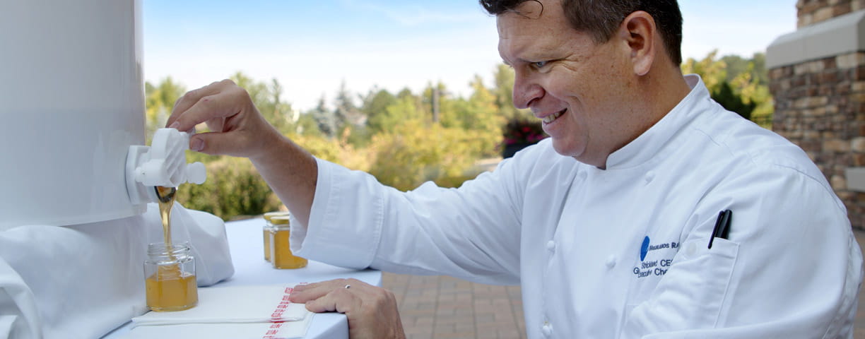 Chef Strickland pours honey that was made on site.