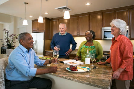 Two couples have cocktails in an apartment.