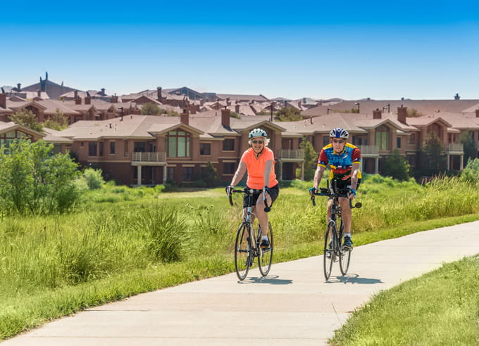 Two cyclists ride around the community.