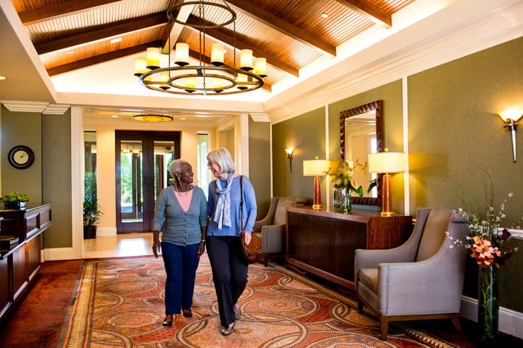 Two women walk together in the Vi at Highlands Ranch lobby.