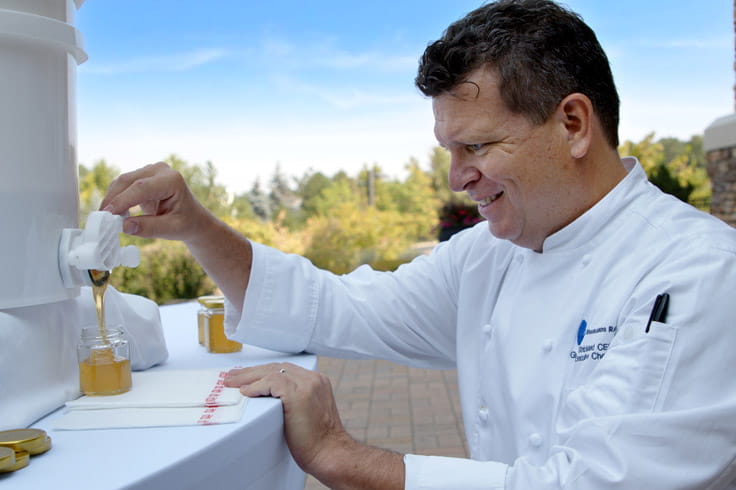 Chef Strickland pours honey made from bees at Highlands Ranch.