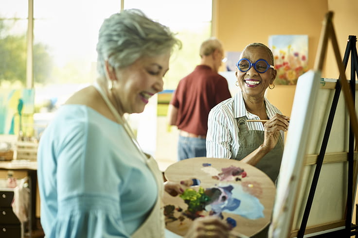 Women paint at art class.