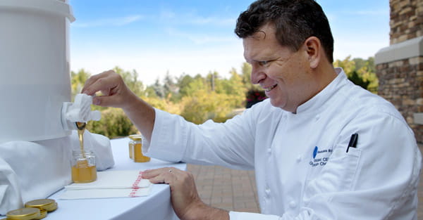 Chef Strickland pours honey from the bees at Vi at Highlands Ranch.