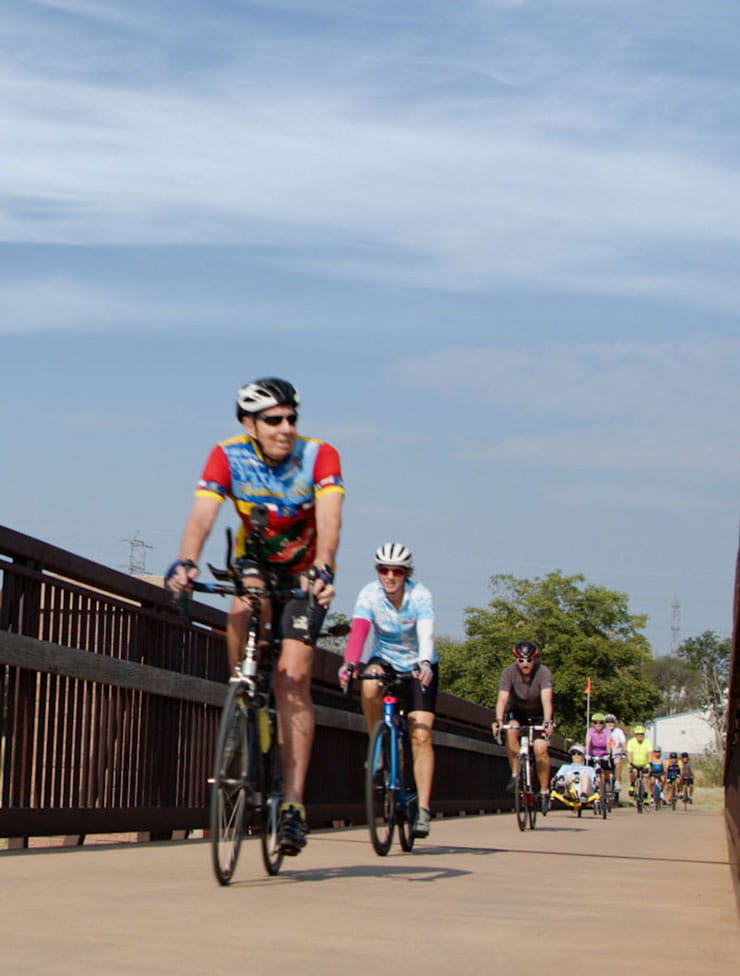 The Highlands Ranch Easy Riders cycle across a bridge.