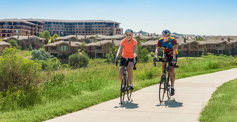 Two people ride bikes on the paths around Vi at Highlands Ranch.