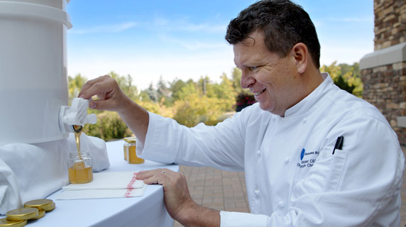 Chef Greg Strickland pours honey from the hives on-site at Vi at Highlands Ranch.