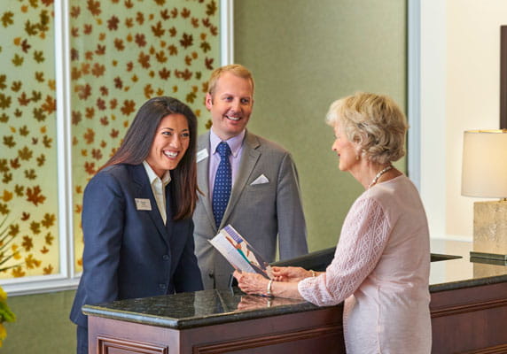 A resident chats with the front desk staff.