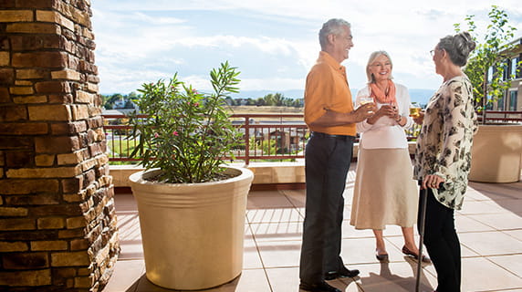 Three people socialize outside.