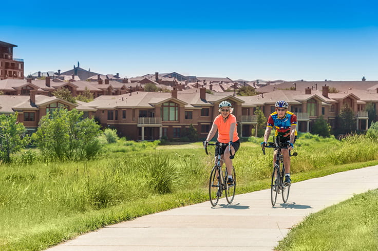 Two people ride bikes on the paths around Vi at Highlands Ranch.