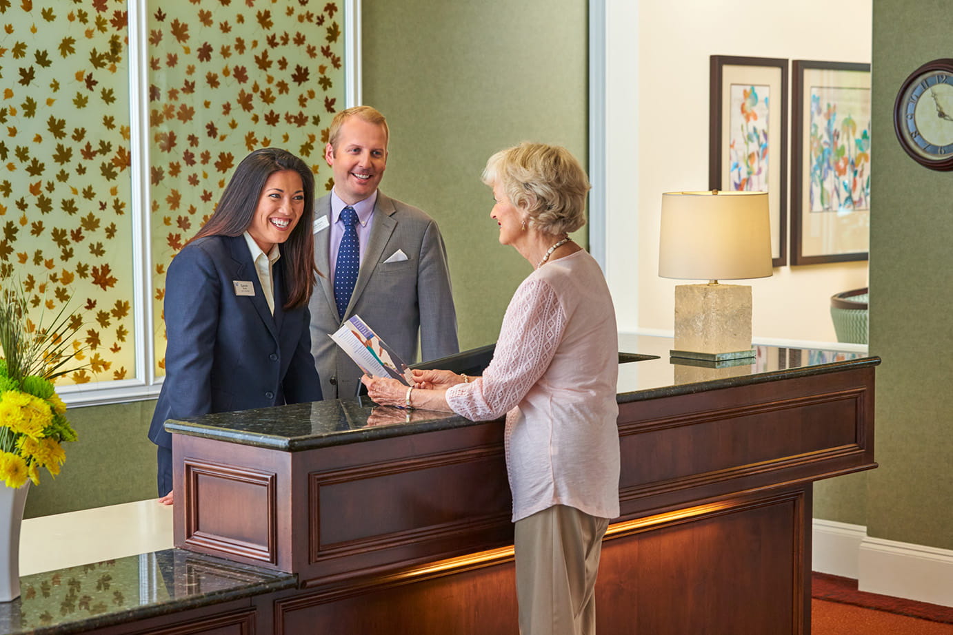 A resident receives assistance at the front desk.