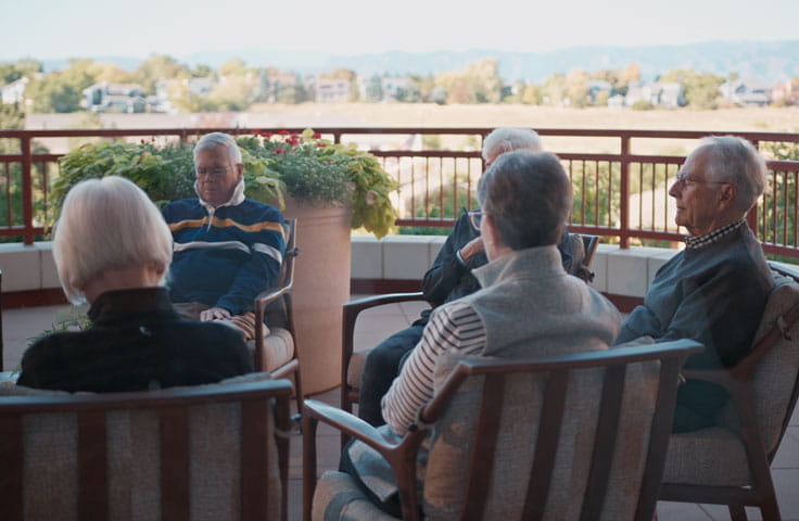 Residents meditate together as a group outside.