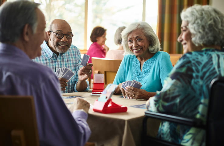 Four people sit together at a bridge table.