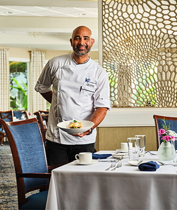 Executive Chef Jose Cathcart holding a plate of food.