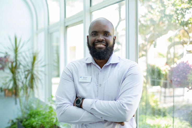 A staff member smiles in the green house.