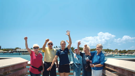 Angela and club participants smile and put their hands in the air.
