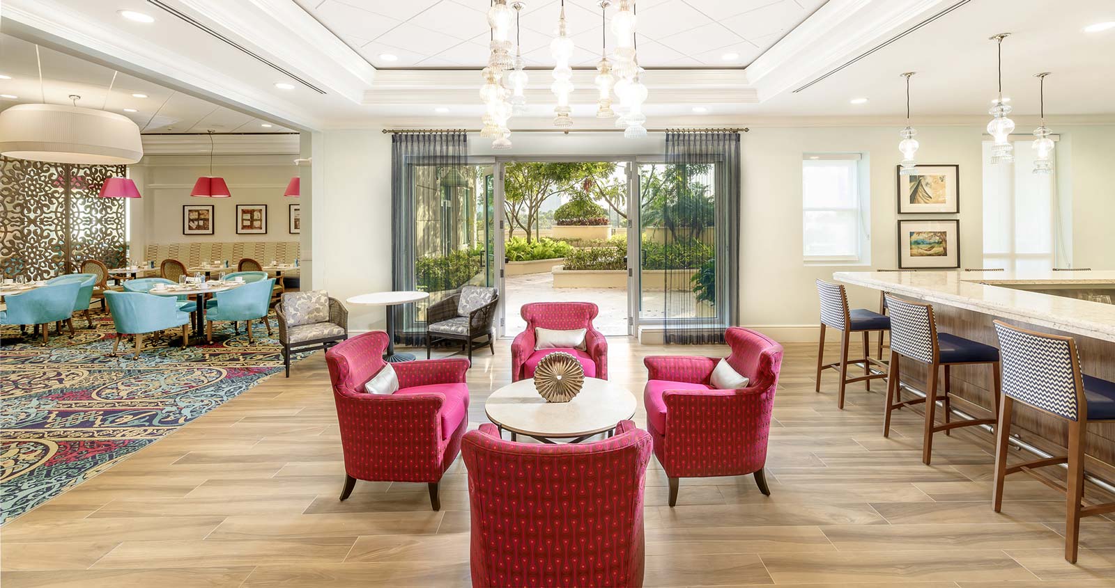 Aventura community common space, fuchsia chairs around a coffee table