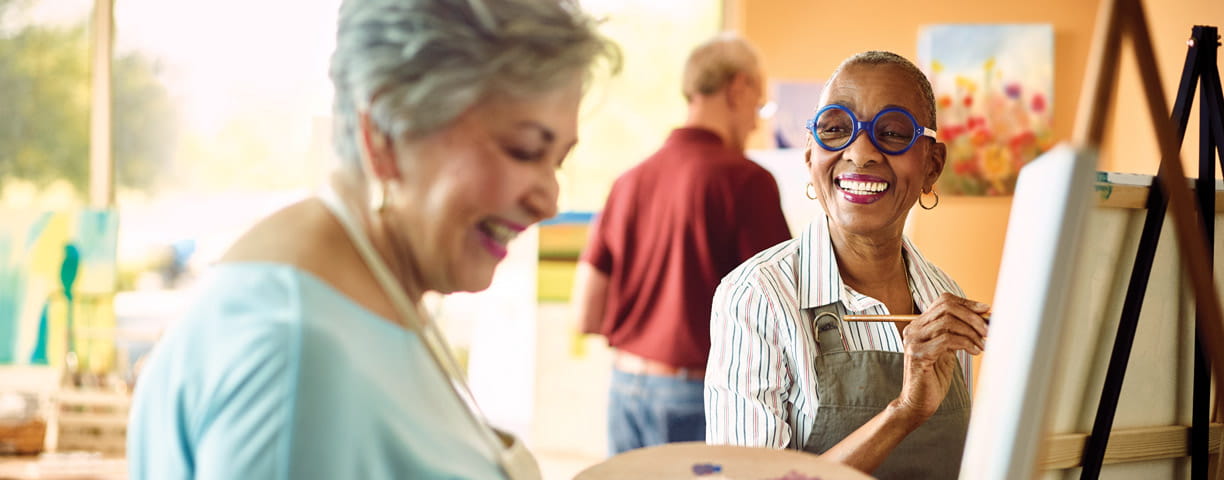 Two women enjoy a painting class together.