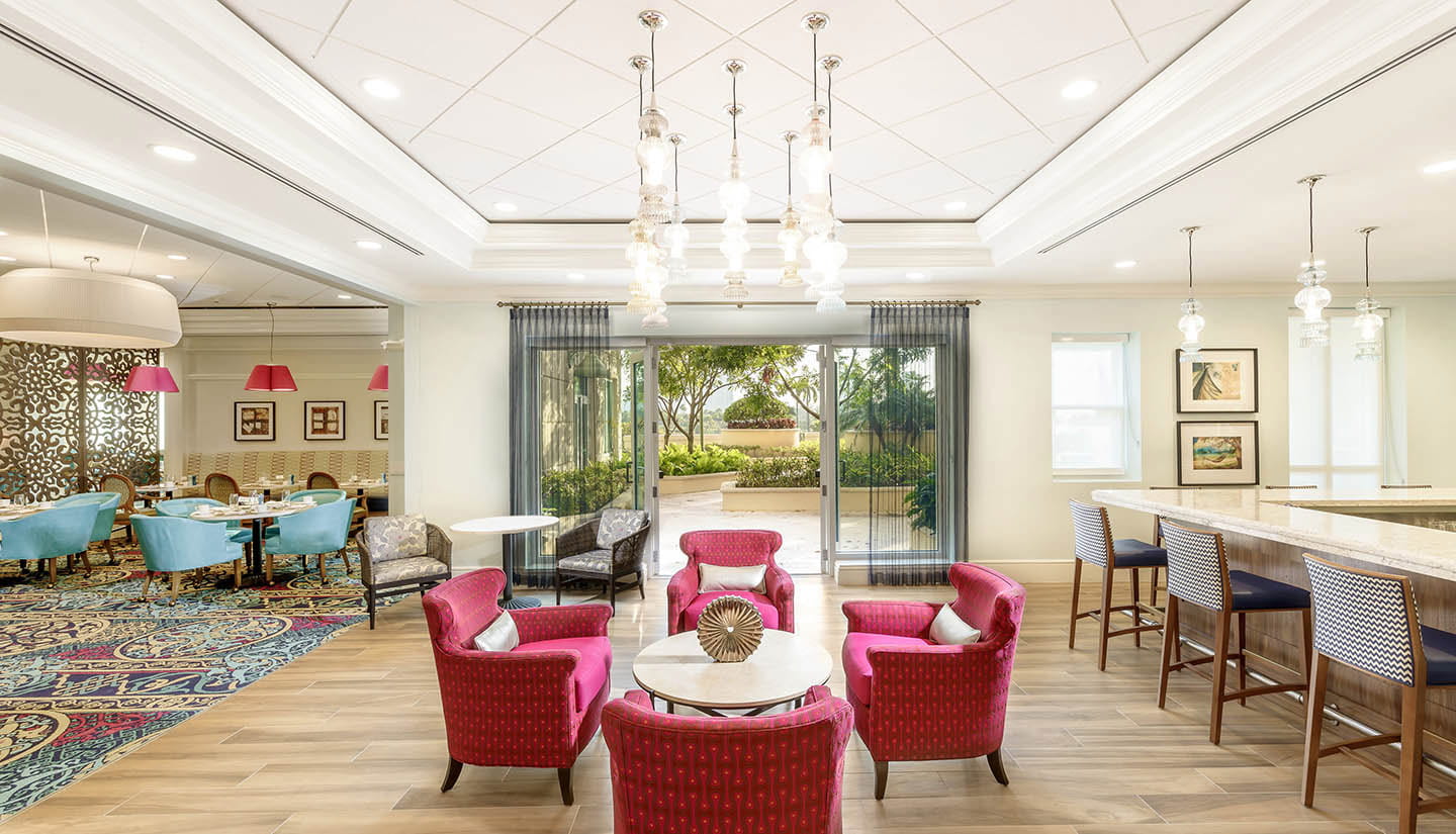 Aventura community common space, fuchsia chairs around a coffee table