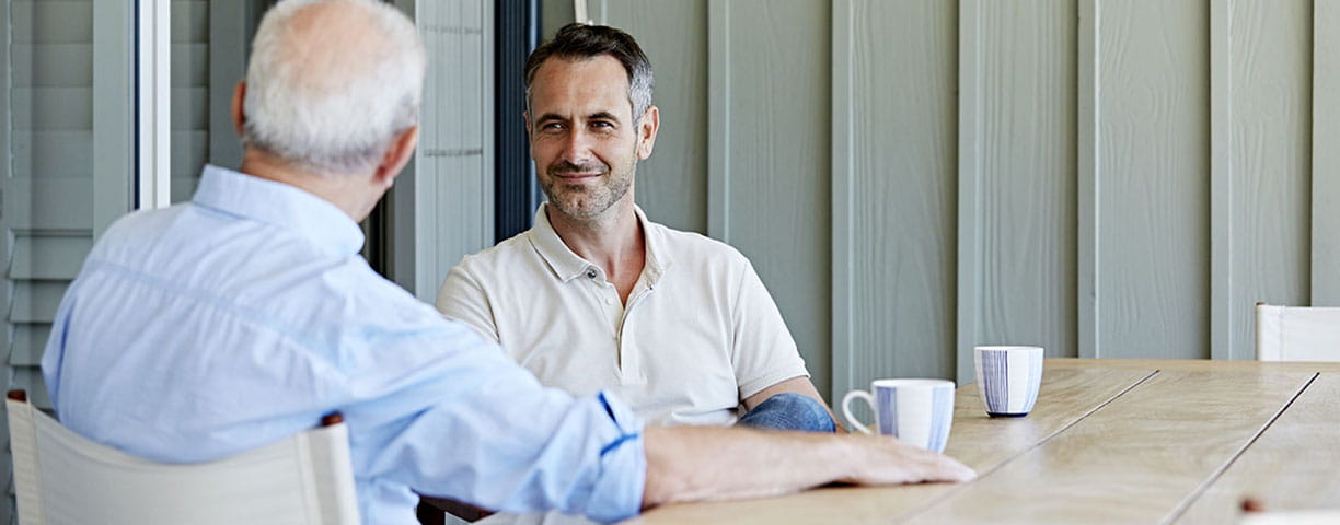 Two men sitting at a table with coffee
