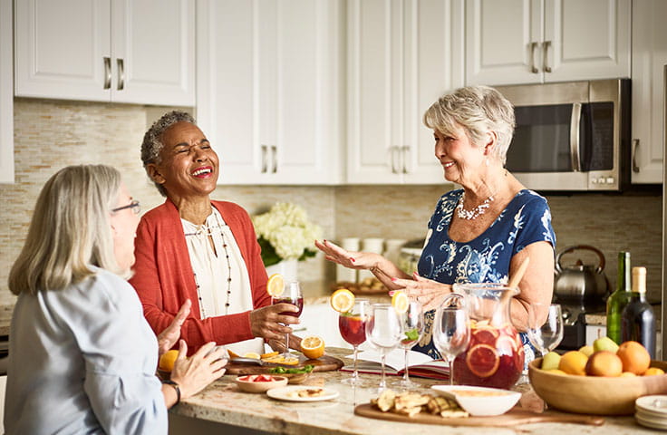 Women drink sangria and laugh in Vi residence kitchen