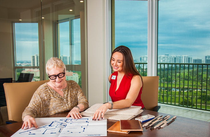 A woman reviews blue prints with a staff member.