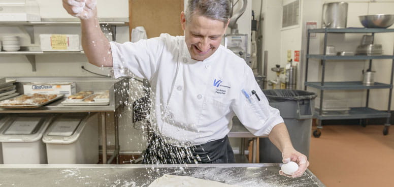 The community's pastry chef prepares dough.