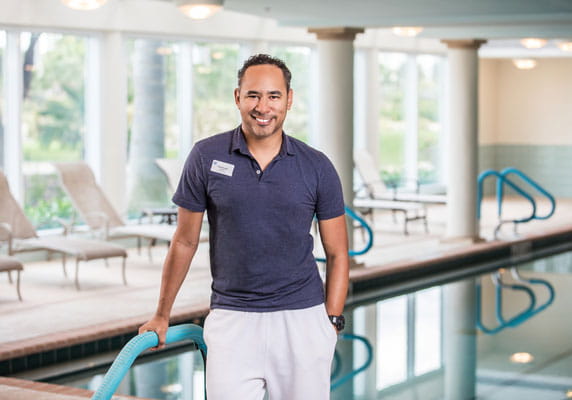 The fitness coordinator stands in front of the pool.
