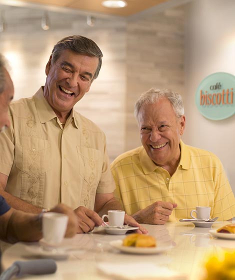 Three men laughing and drinking espresso