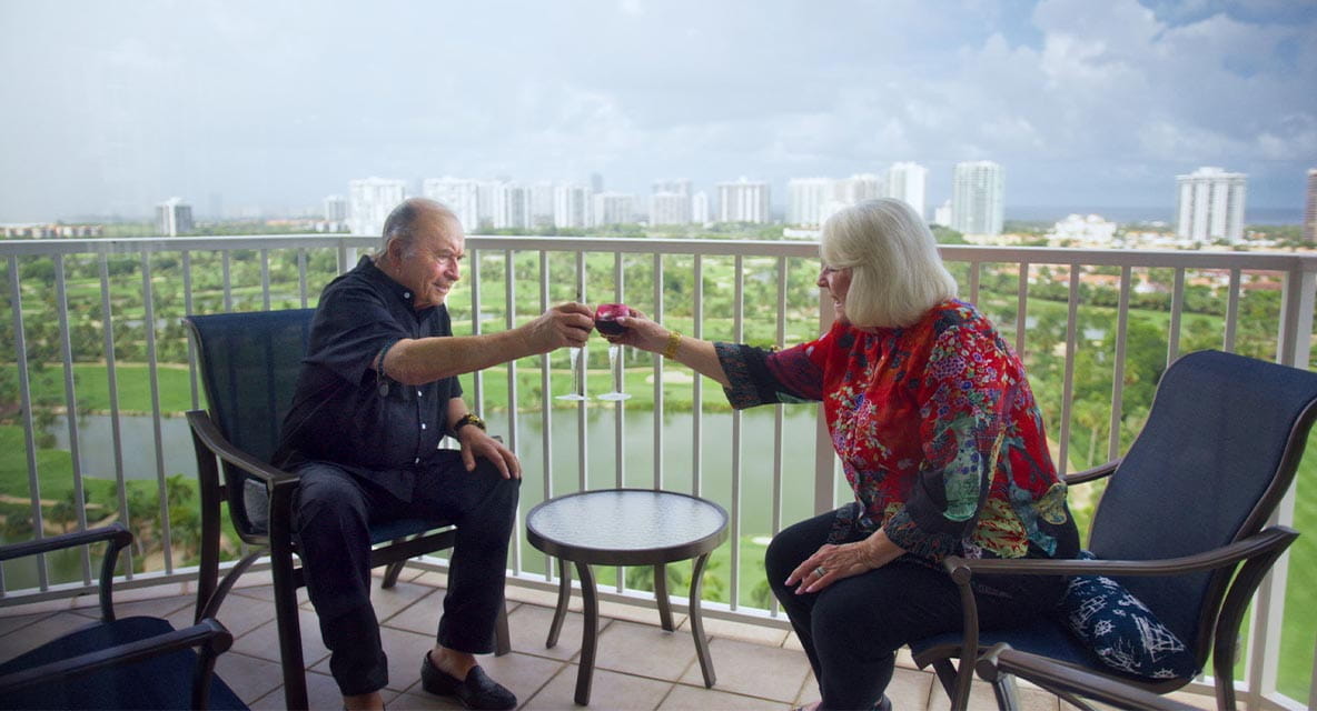 A couple having drinks on the balcony. 