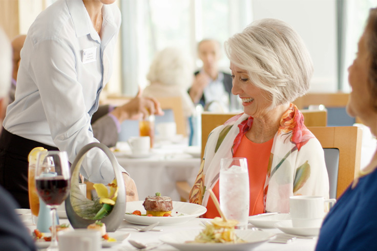 A women being served a plate of food. 