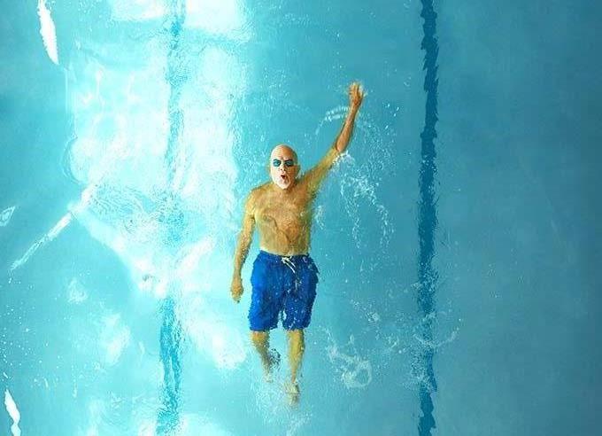 A man swimming in an indoor pool.