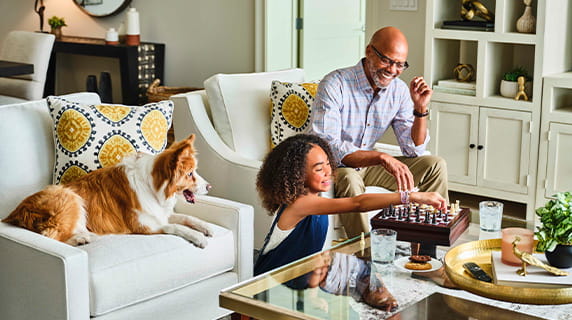 A grandfather and granddaughter playing chess.