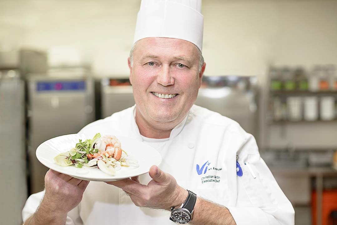 Vi Executive Chef Christian Martin holds up a plate of food
