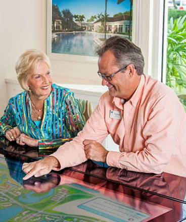A man and woman review the community map in the sales office