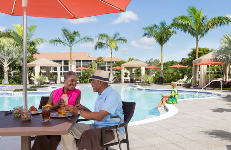 A couple dines poolside.