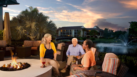 Residents sit by a firepit at one of the clubhouses.