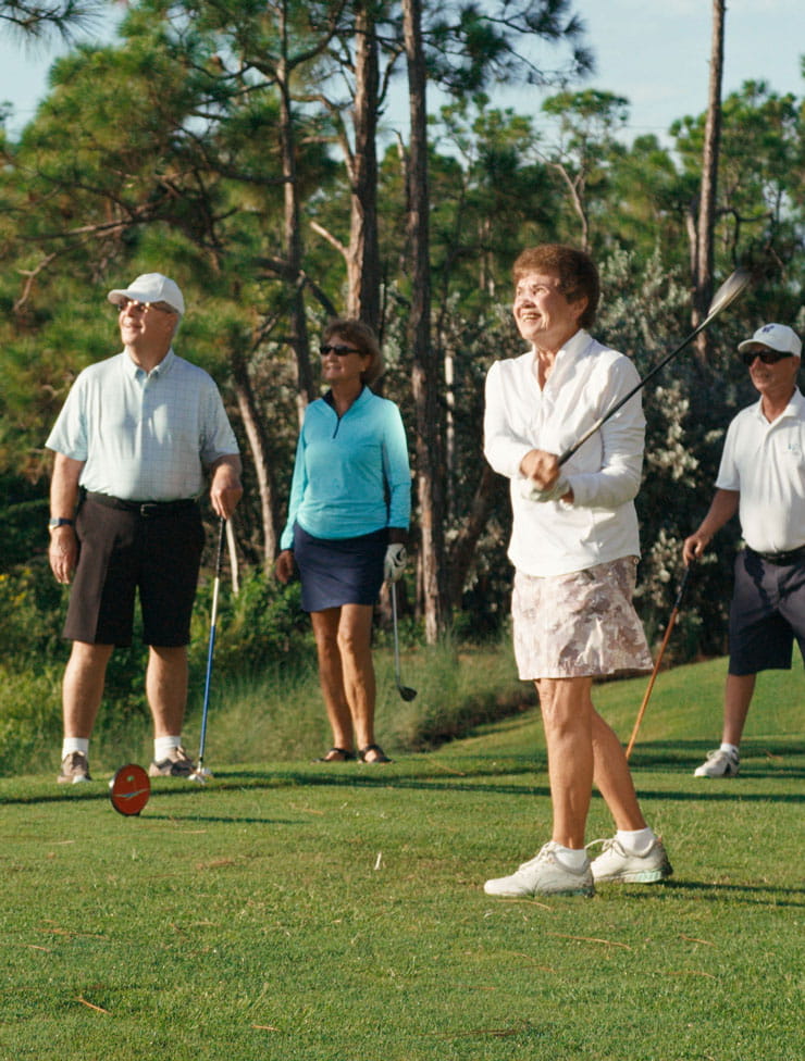 Two couples play golf at Bentley Village.