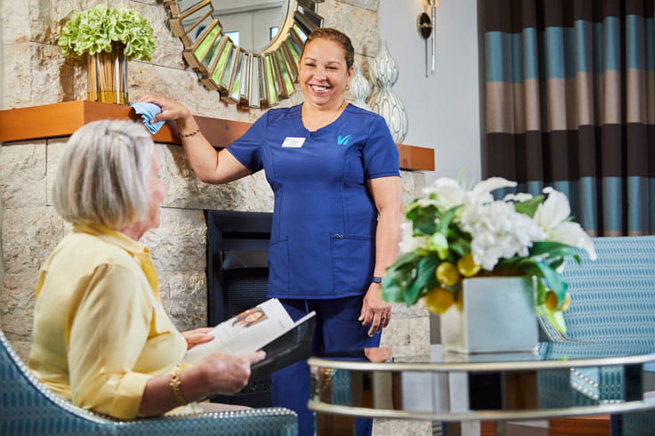 A member of housekeeping chats with a resident.