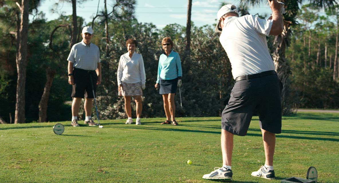 A group of people golfing. 