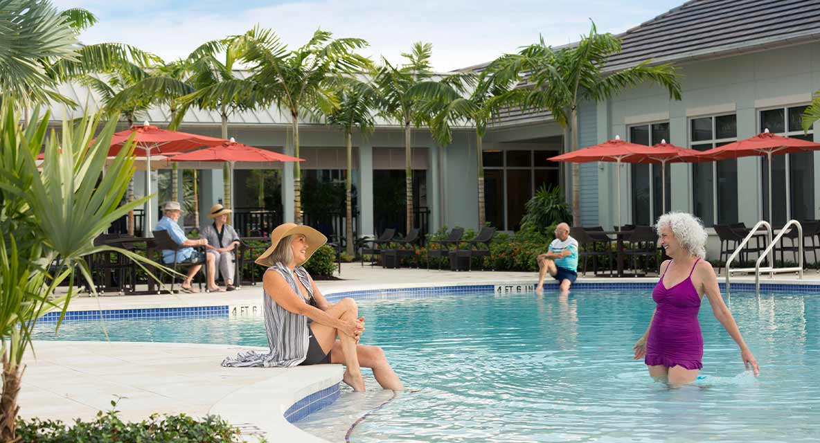Women hanging out in the outdoor pool at Vi at Bentley Village. 
