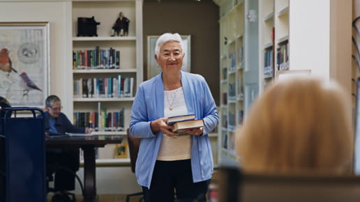 A resident walks her books to the checkout desk.