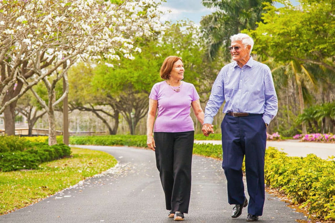 A couple walks through Bentley Village's grounds.