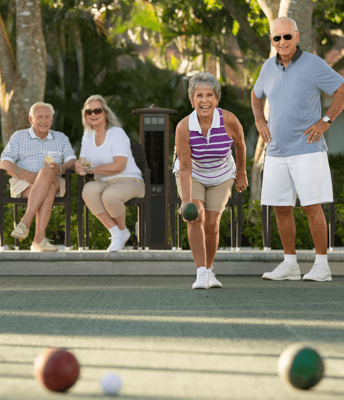 Two couples play bocce ball at Vi at Bentley Village.