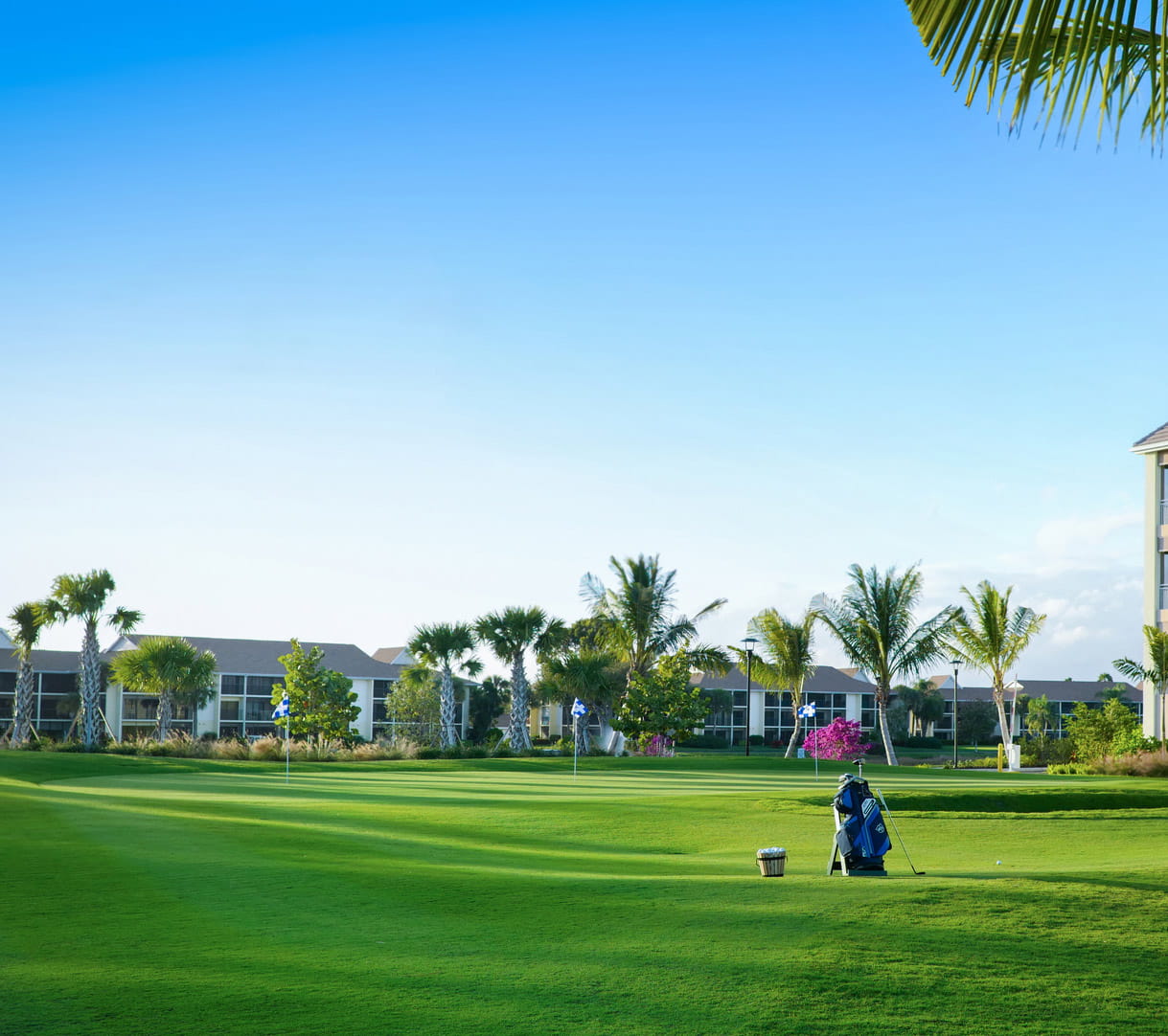 Golf clubs sit on a golf course with the BV clubhouse in the background.