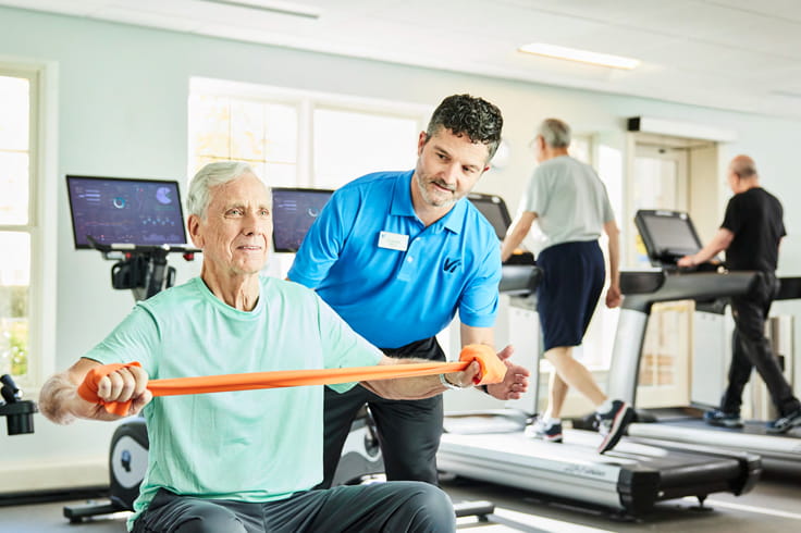 A man works out with a staff member.