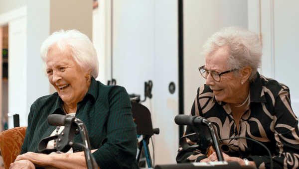 Two women laugh together during an improv class.