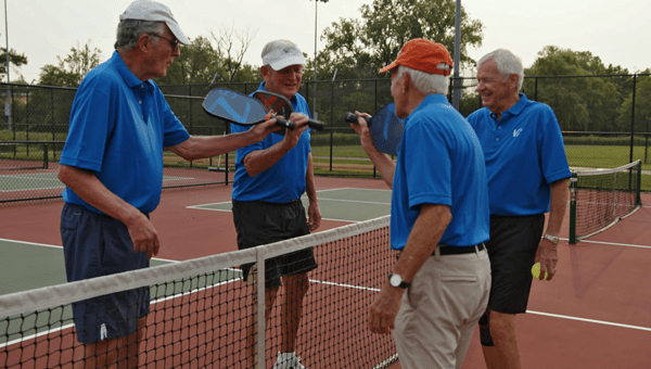 Four Vi residents hit paddles after a pickleball game.