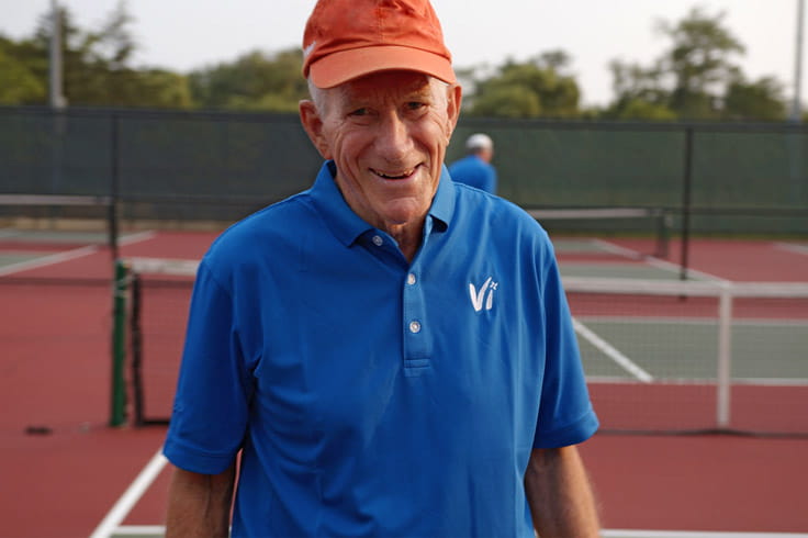 A resident in a Vi polo plays pickleball.