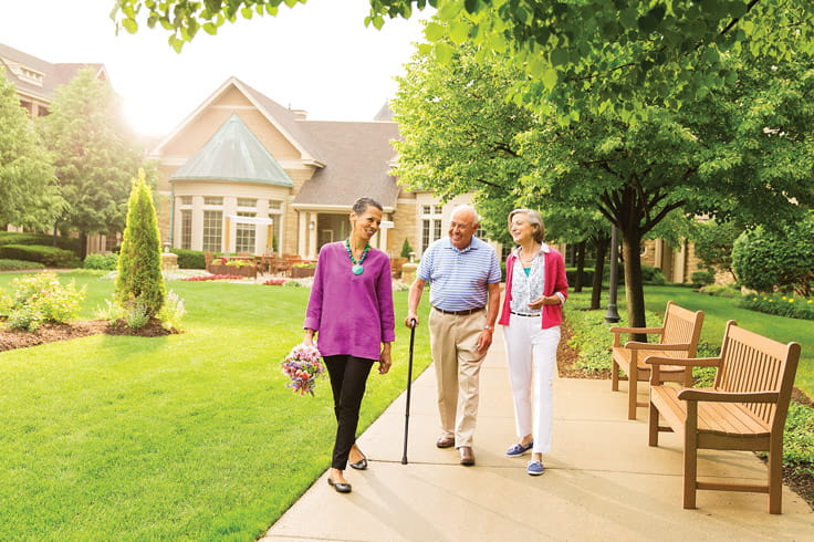 Residents walk down a pathway at Vi at The Glen.